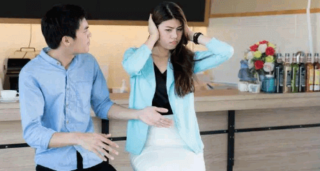 A girl closing her ears to avoid hearing what she is being told